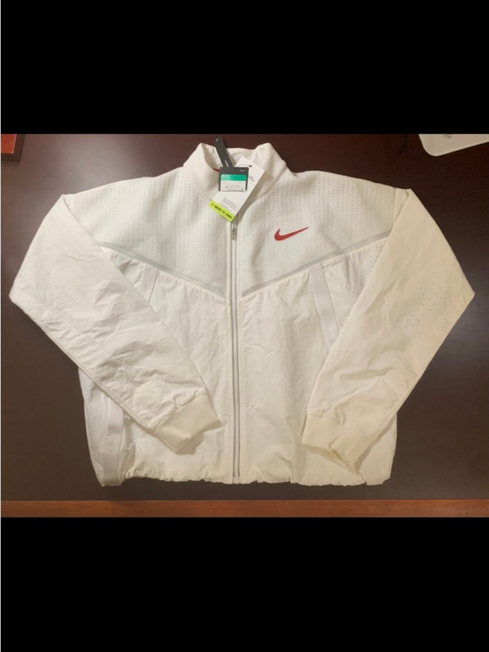 Nike Sportswear "Move to Zero" Women’s Jacket in white with a red swoosh.